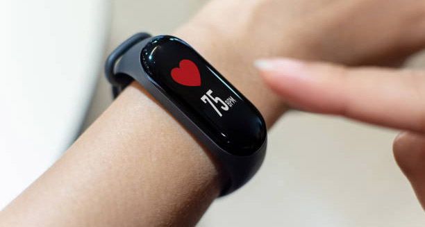Smartwatch displaying heart rate of 75 bpm on a person’s wrist