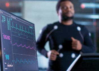 Man running on treadmill during ECG test with heart rate monitor, promoting heart block prevention