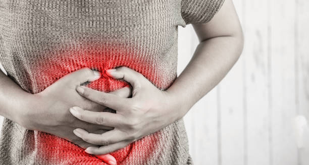 Person clutching stomach in pain with red highlight indicating abdominal discomfort