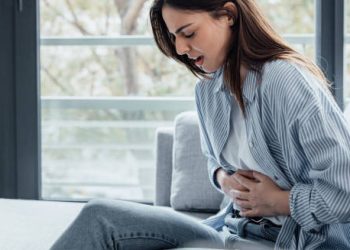 Woman holding stomach in pain from gastritis symptoms
