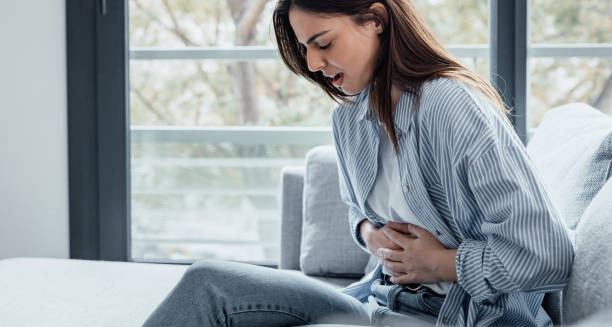 Woman holding stomach in pain from gastritis symptoms