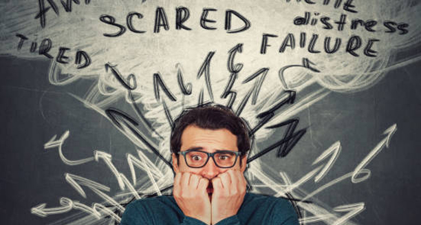 Anxious man surrounded by scribbled thoughts and words like “scared” and “failure”