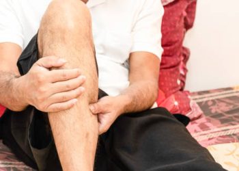 Man experiencing leg weakness and tingling, early symptoms of Guillain-Barré syndrome