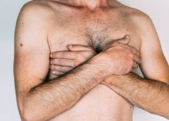 Man covering chest due to breast swelling or tenderness