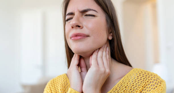 Woman holding her neck in discomfort, showing a common symptom of Hodgkin lymphoma
