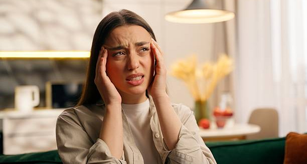 Woman holding her head in pain due to severe headache