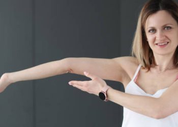 Woman demonstrating hyperextension of the elbow, a symptom of Joint Hypermobility Syndrome