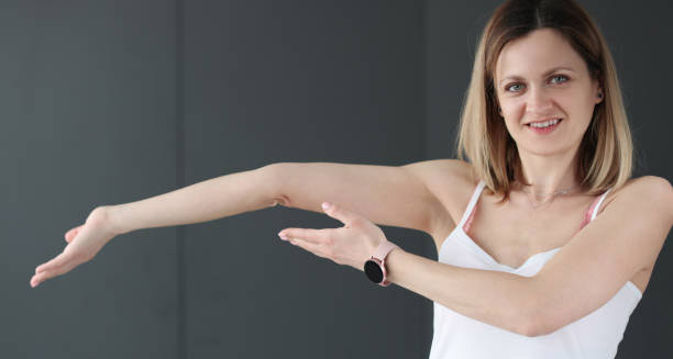 Woman demonstrating hyperextension of the elbow, a symptom of Joint Hypermobility Syndrome