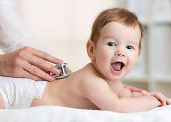 Doctor examining baby for flat head syndrome treatment
