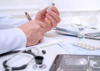 Doctor preparing injectable medication for vascular disorder treatment