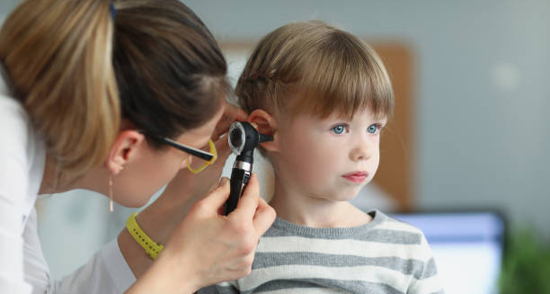 Doctor using otoscope to examine a child's ear for glue ear treatment options