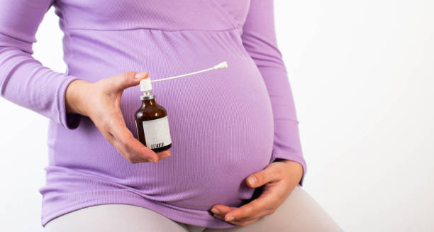Pregnant woman holding medication for Group B Strep treatment