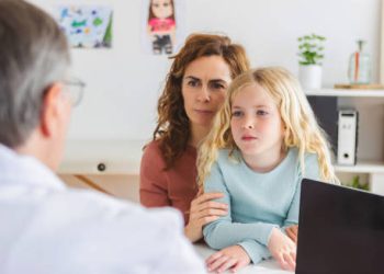 Child receiving medical advice for growing pains
