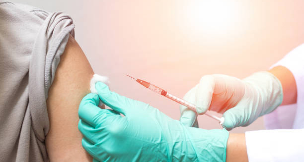 Medical professional administering vaccine to a patient’s arm