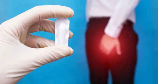 Doctor holding suppository for haemorrhoid treatment