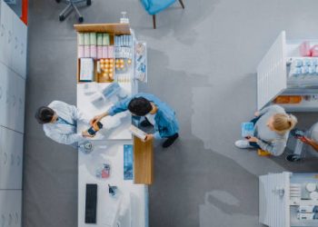 Pharmacist assisting a customer in selecting treatment for hair dye reactions.