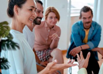 Group therapy session with people smiling and engaging in open discussion