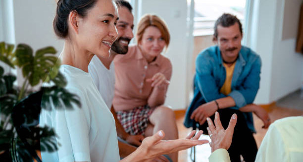 Group therapy session with people smiling and engaging in open discussion