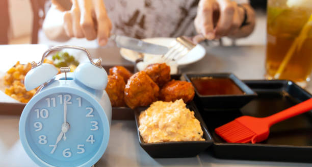 Meal tray with sauces and clock representing dietary timing for treating hiatus hernia