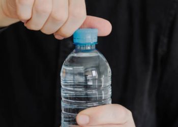 Person opening a bottle of water to stay hydrated