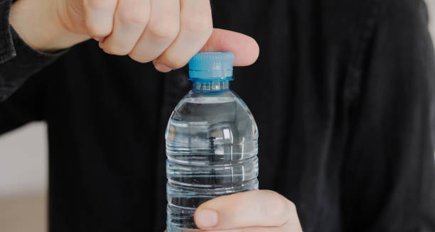 Person opening a bottle of water to stay hydrated