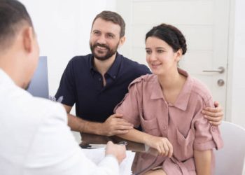 Happy couple discussing infertility treatment with doctor