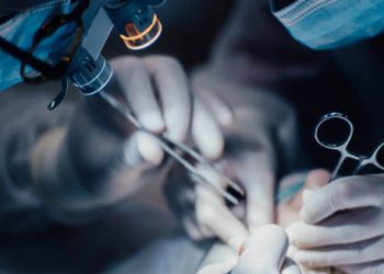 Surgeons performing a medical procedure under magnification lights