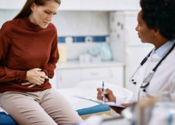 Woman with abdominal pain consulting a doctor for irritable bowel syndrome treatment