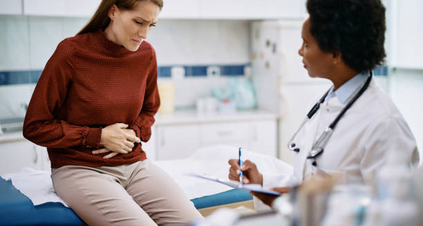 Woman with abdominal pain consulting a doctor for irritable bowel syndrome treatment