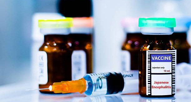 Close-up of vaccine vials and syringe labeled Japanese Encephalitis for treatment and prevention
