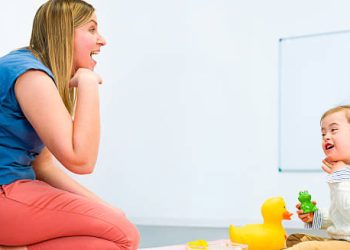 Speech therapy session with young child with Down syndrome and female therapist