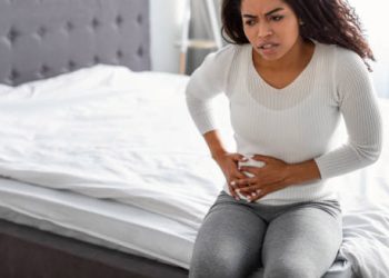 Woman clutching her abdomen in pain, showing symptoms of a kidney infection